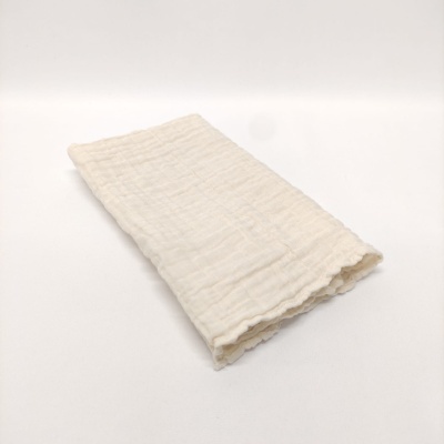 Pano branco com textura enrugada dobrado sobre superfície branca