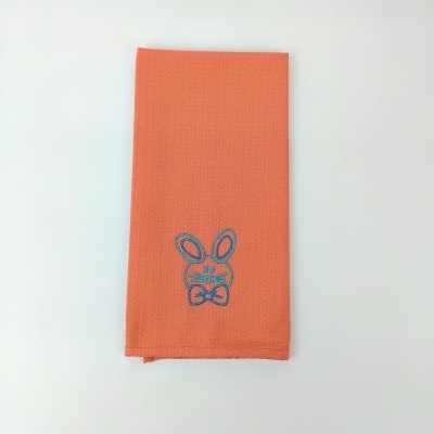 Toalha laranja com bordado azul de coelho e laço