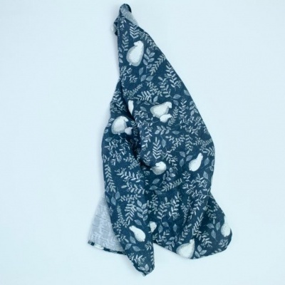 Pano de cozinha azul com padrão de folhas e legumes em fundo branco