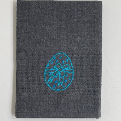 Toalha cinzenta com bordado azul de ovo com laço.