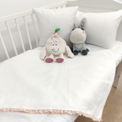 Cama branca com bichos de peluche e almofadas brancas