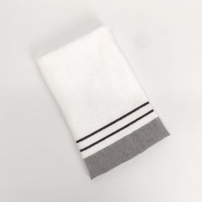 Toalha branca com riscas pretas e faixa cinza na borda