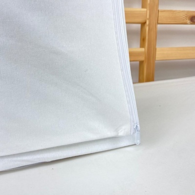 Capa protetora branca com fecho de correr sobre superfície branca com estrutura de madeira