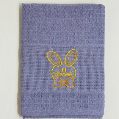 Toalha azul claro com bordado amarelo de coelho e textura quadriculada.