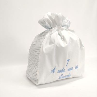Saco de roupa branco com laterais de pontos azuis e inscrição bordada