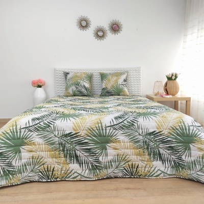Cama de casal com roupa de cama estampada de folhas tropicais verdes e amarelas