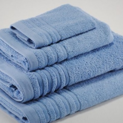 Conjunto de toalhas azuis empilhadas sobre superfície branca