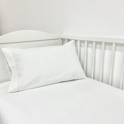 Cama de bebé branca com colchão e almofada brancos