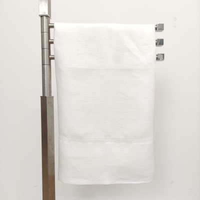 Toalha branca pendurada numa estrutura metálica