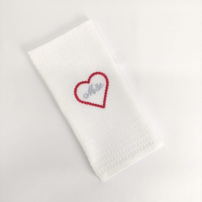 Toalha branca com bordado de coração vermelho e texto 'Mãe'