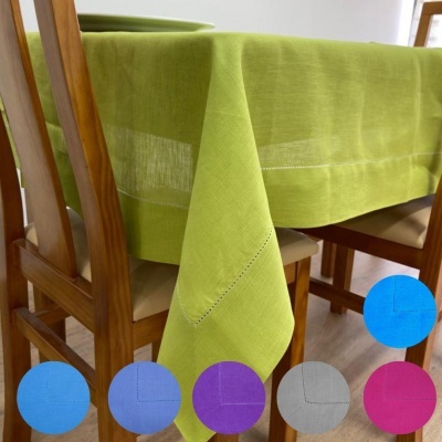 Toalha de mesa verde clara em tecido liso sobre mesa de madeira com cadeiras