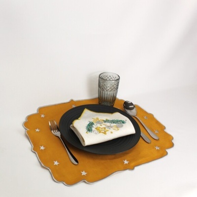 Conjunto de jantar com prato preto e guardanapo decorado sobre individual amarelo