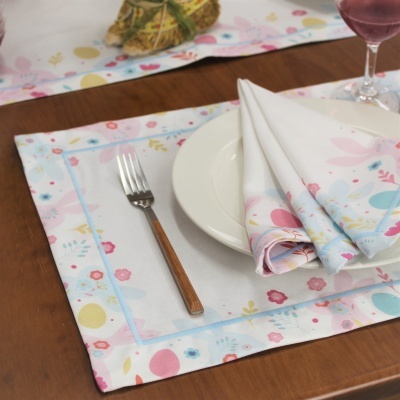 Jogo americano e guardanapo branco com padrão colorido floral e geométrico sobre mesa