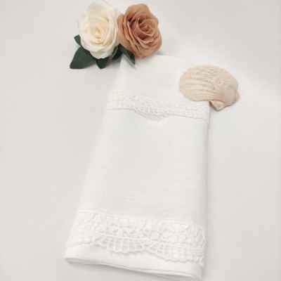 Toalha branca com bordado de renda, flores artificiais bege e creme, concha marinha clara