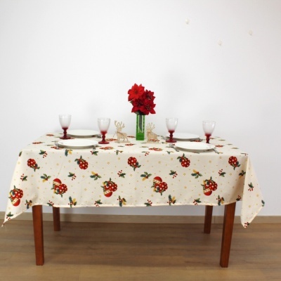 Mesa de madeira com toalha estampada de joaninhas, pratos, copos, flores vermelhas e decoração de rena