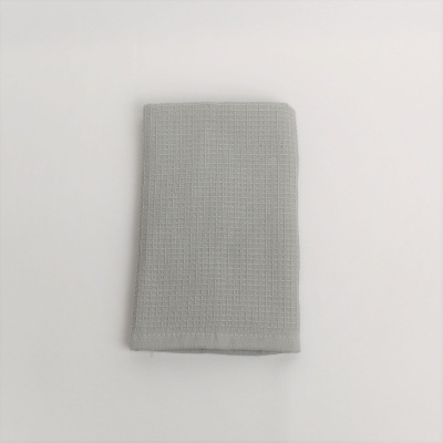 guardanapo ou toalha cinzenta com padrão quadriculado sobre superfície branca