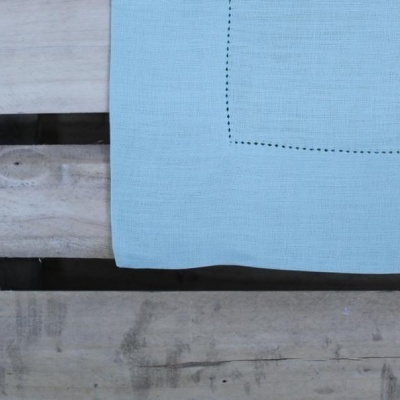 tecido azul claro com costura preta sobre paletes de madeira rústica