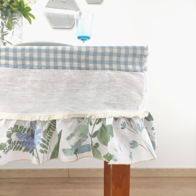 Toalha de mesa com padrões xadrez e floral em mesa de madeira