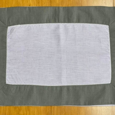 Toalha de mesa retangular cinzento claro com borda cinzenta escura sobre madeira