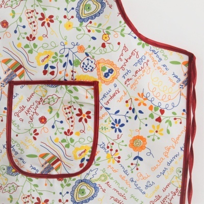Avental colorido com padrão floral e texto em português, com bolso e bordas vermelhas