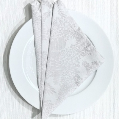 Guardanapo branco com padrão floral em prato branco