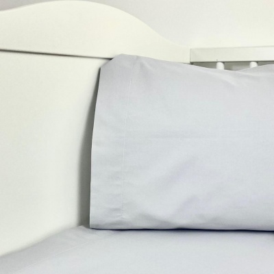 Fronha de almofada e lençol brancos numa cama com cabeceira branca