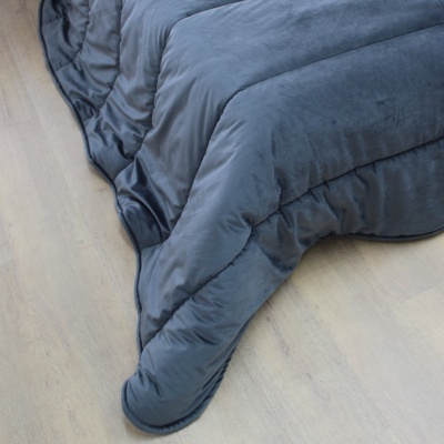 Edredão azul escuro macio em chão de madeira clara