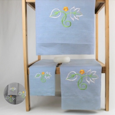 Conjunto de toalhas azuis com bordado floral colorido em estrutura de madeira