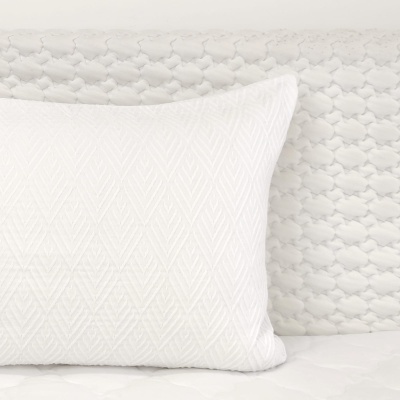 Almofada branca com padrão geométrico em relevo e fundo branco texturizado