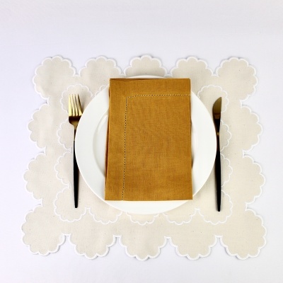 Conjunto de mesa com guardanapo castanho sobre prato branco e talheres