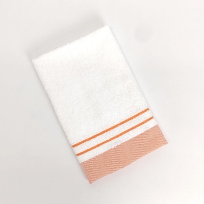 Toalha branca com riscas laranjas e faixa salmão
