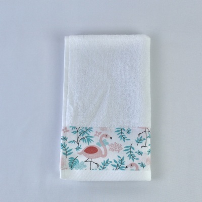 Toalha branca com estampa de flamengos e folhas na faixa inferior