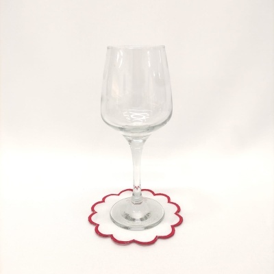 Copo de vidro transparente sobre porta-copo em forma de flor