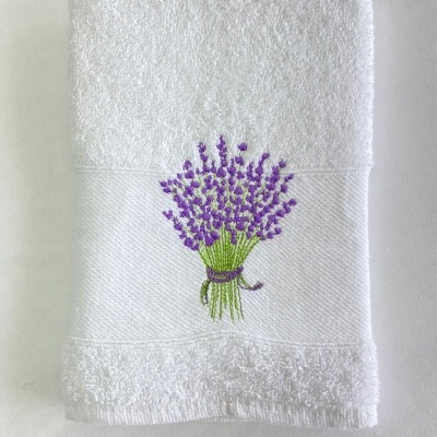 Toalha branca com bordado de ramo de flores roxas e caules verdes