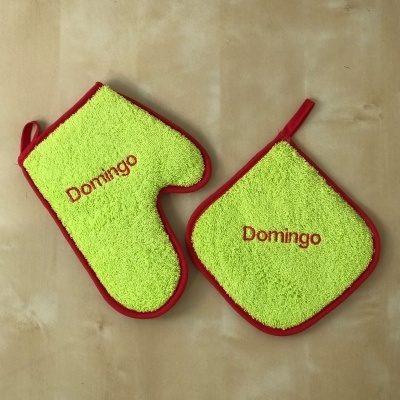 Conjunto de luva e pega de panela verde com bordas vermelhas e texto 'Domingo'