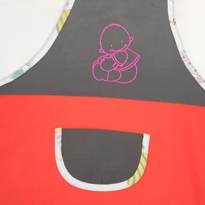 Avental cinza escuro e vermelho com desenho rosa de bebé e bolso frontal