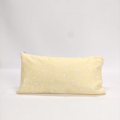 Almofada amarela com padrão branco de estrelas e luas