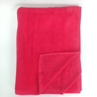 Toalha de banho rosa vibrante dobrada sobre fundo branco