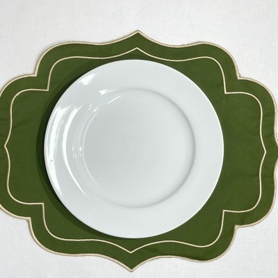 Prato branco em individual verde com borda dourada ondulada