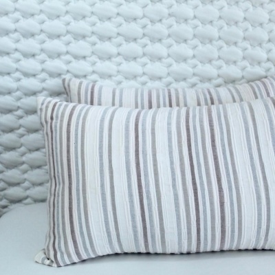 Duas almofadas riscas cinza e bege sobre superfície branca texturada