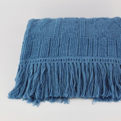 Manta azul de malha com padrão texturizado e franjas longas