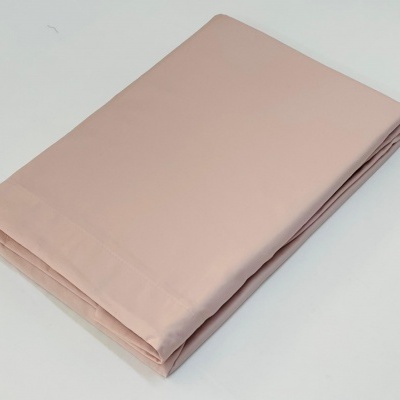 Pano de tecido cor-de-rosa claro dobrado sobre superfície branca