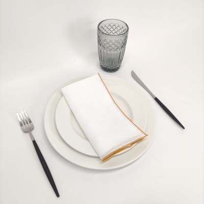 Conjunto de prato, talheres e copo sobre mesa branca