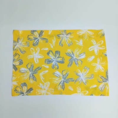 Tecido amarelo com padrão de flores brancas e cinzentas