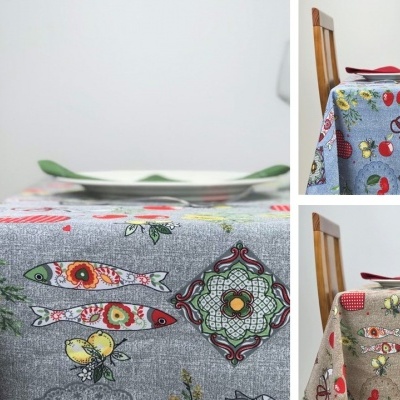 Toalhas de mesa com padrões coloridos de peixes e flores em diferentes cores sobre mesa de madeira.