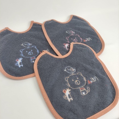 Babetes cinzentos escuros com bordas rosa e desenho de urso, girafa e texto 'hello!'