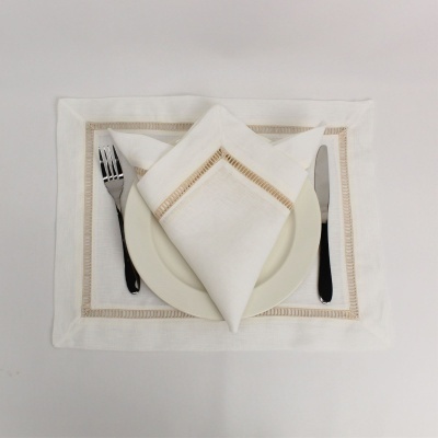 Jogo americano e guardanapo branco com bordas bege, prato branco, faca e garfo