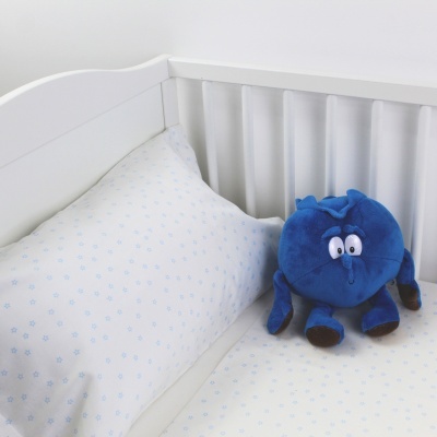 Berço branco com roupa de cama branca com flores azuis e peluche azul