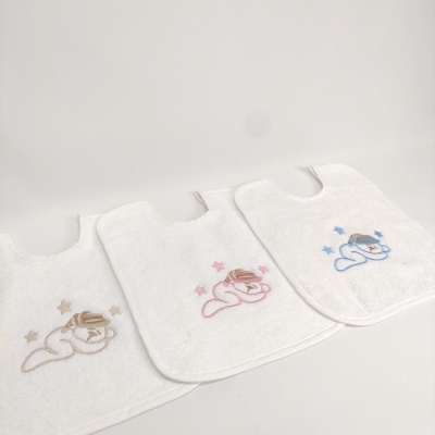 Três babetes de tecido branco com ursinhos bordados em bege, rosa e azul