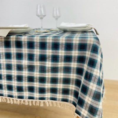 Toalha de mesa xadrez azul branco castanho com franjas em mesa posta com pratos e taças